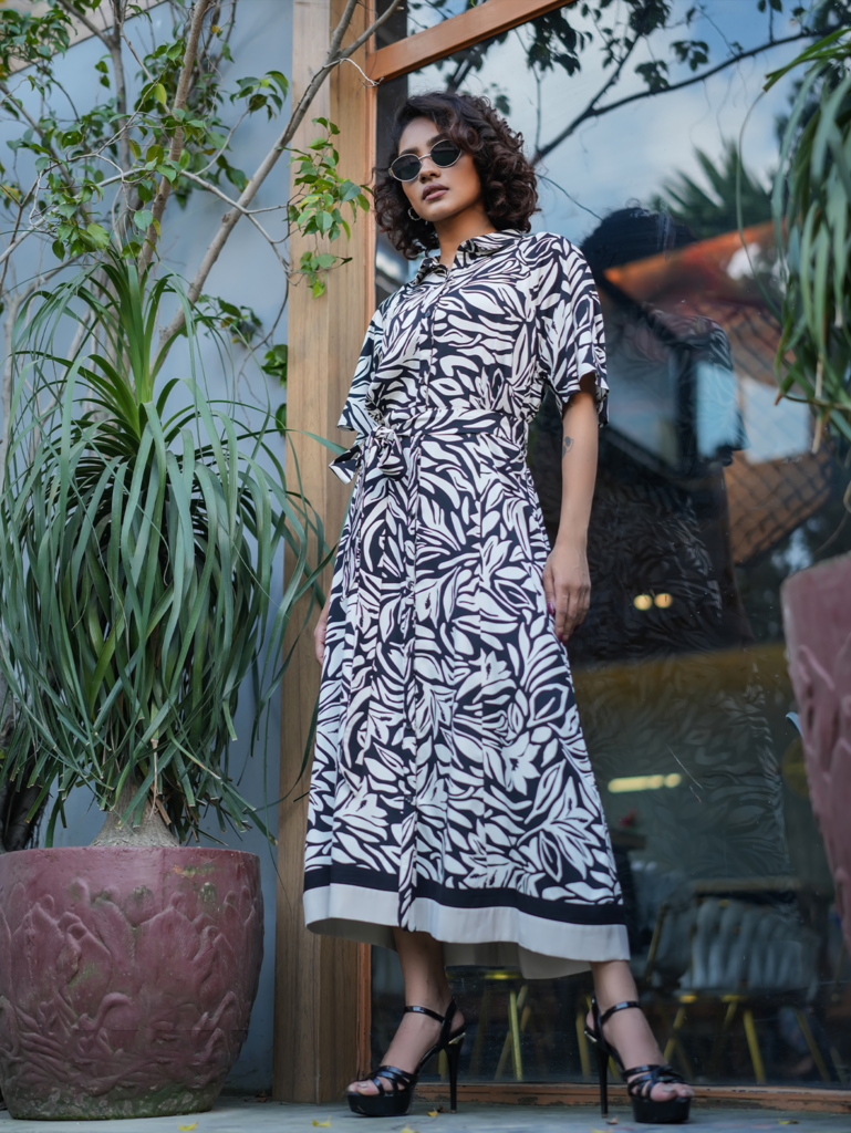 Model wearing ARIZA Monochrome Printed Belted Long Tunic with a shirt collar, matching waist tie and black-and-white botanical pattern.