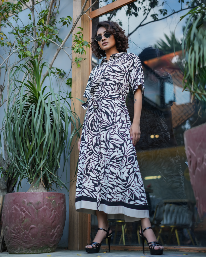 Model wearing ARIZA Monochrome Printed Belted Long Tunic with a shirt collar, matching waist tie and black-and-white botanical pattern.